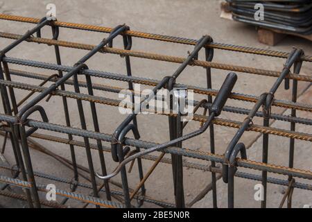 Utensili per lavoratori per barre di acciaio per l'edilizia in cantiere. Pinza, gancio e fili di ferro per la lavorazione a maglia di vergelle metalliche. Foto Stock