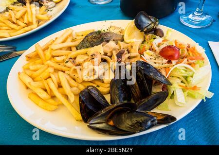 Piatto di pesce con patatine fritte e piccole verdure a Malta Foto Stock