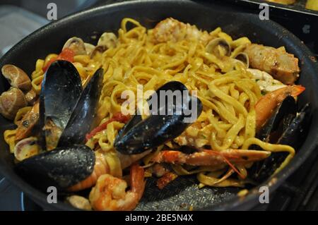 Tagliolini allo scoglio o spaghetti con pesce serviti con gamberi e altri conchiglie Foto Stock