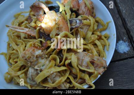 Tagliolini allo scoglio o spaghetti con pesce serviti con gamberi e altri conchiglie Foto Stock