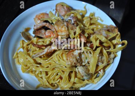 Tagliolini allo scoglio o spaghetti con pesce serviti con gamberi e altri conchiglie Foto Stock