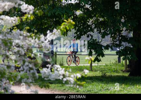 Londra, UK, 12 aprile 2020: La domenica di Pasqua la gente osserva le regole di distanza sociale mentre si esercitano e si prende aria fresca al sole su Clapham Common. Anna Watson/Alamy Live News Foto Stock