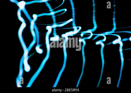 Onde sonore al buio. Note musicali nel colore blu visibile al buio Foto Stock