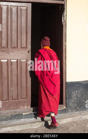 Monaco buddista che entra in una stanza buia al monastero di Rumtek a Sikkim, India. Foto Stock