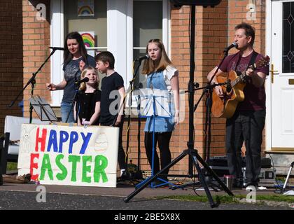 Glasgow, Scozia, Regno Unito, 12th, aprile, 2020. Lockdown a Glasgow. Una famiglia del southside mette in uno spettacolo musicale all'aperto questa soleggiata Domenica di Pasqua alla gioia dei vicini durante l'attuale blocco a causa della pandemia del Covid19. Foto Stock