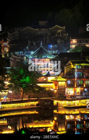 Architettura tradizionale cinese illuminata all'interno del villaggio Fenghuang di notte nella provincia cinese di Hunan. Foto Stock