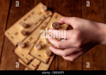 famiglia vintage interessante lotto gioco bingo, la mano tiene un barile con un numero Foto Stock