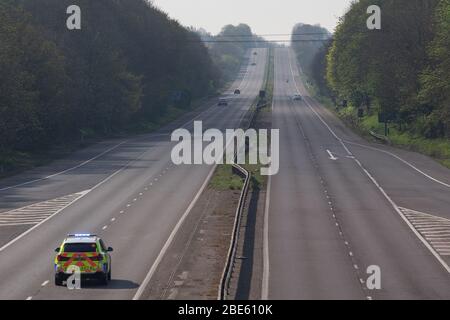 Molto tranquillo, quasi deserto A! Autostrada allo svincolo 7 Stevenage durante l'arenamento di Coronavirus nel Regno Unito con auto di polizia Foto Stock