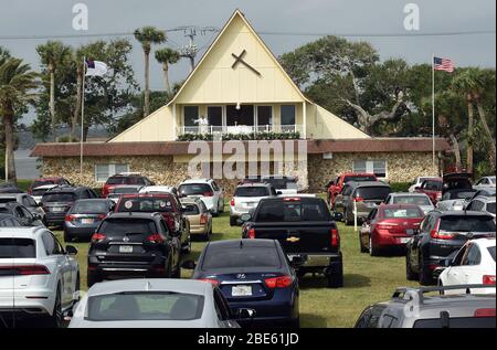 12 aprile 2020 - Daytona Beach Shores, Florida, Stati Uniti - persone in auto assistere Pasqua Domenica servizi presso la Daytona Beach Drive-in Christian Church come un modo per praticare le distanze sociali durante la pandemia di coronavirus il 12 aprile 2020 a Daytona Beach Shores, Florida. L'ordine di soggiorno a casa della Florida esenta i servizi religiosi, ma il governatore Ron DeSantis ha consigliato di non partecipare a riunioni religiose affollate. (Paul Hennessy/Alamy) Foto Stock