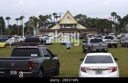 12 aprile 2020 - Daytona Beach Shores, Florida, Stati Uniti - persone in auto assistere Pasqua Domenica servizi presso la Daytona Beach Drive-in Christian Church come un modo per praticare le distanze sociali durante la pandemia di coronavirus il 12 aprile 2020 a Daytona Beach Shores, Florida. L'ordine di soggiorno a casa della Florida esenta i servizi religiosi, ma il governatore Ron DeSantis ha consigliato di non partecipare a riunioni religiose affollate. (Paul Hennessy/Alamy) Foto Stock