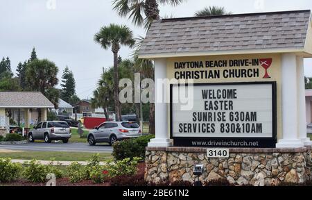 12 aprile 2020 - Daytona Beach Shores, Florida, Stati Uniti - le persone in auto arrivano per i servizi della Domenica di Pasqua alla Daytona Beach Drive-in Christian Church come un modo per praticare le distanze sociali durante la pandemia di coronavirus il 12 aprile 2020 a Daytona Beach Shores, Florida. L'ordine di soggiorno a casa della Florida esenta i servizi religiosi, ma il governatore Ron DeSantis ha consigliato di non partecipare a riunioni religiose affollate. (Paul Hennessy/Alamy) Foto Stock