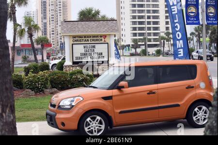 12 aprile 2020 - Daytona Beach Shores, Florida, Stati Uniti - le persone in auto arrivano per i servizi della Domenica di Pasqua alla Daytona Beach Drive-in Christian Church come un modo per praticare le distanze sociali durante la pandemia di coronavirus il 12 aprile 2020 a Daytona Beach Shores, Florida. L'ordine di soggiorno a casa della Florida esenta i servizi religiosi, ma il governatore Ron DeSantis ha consigliato di non partecipare a riunioni religiose affollate. (Paul Hennessy/Alamy) Foto Stock