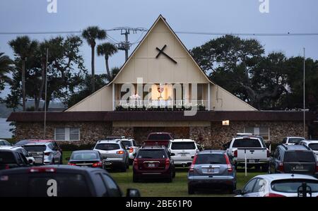 12 aprile 2020 - Daytona Beach Shores, Florida, Stati Uniti - persone in auto assistere Pasqua Domenica servizi presso la Daytona Beach Drive-in Christian Church come un modo per praticare le distanze sociali durante la pandemia di coronavirus il 12 aprile 2020 a Daytona Beach Shores, Florida. L'ordine di soggiorno a casa della Florida esenta i servizi religiosi, ma il governatore Ron DeSantis ha consigliato di non partecipare a riunioni religiose affollate. (Paul Hennessy/Alamy) Foto Stock