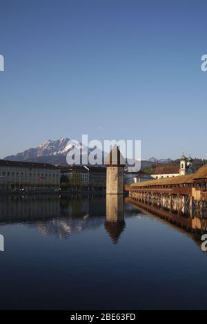 Il ponte della Cappella con la torre dell'acqua di Lucerna, la Svizzera sul fiume Reuss, è il ponte in legno più antico d'Europa. Sul retro si trova il Monte Pilatus. Foto Stock