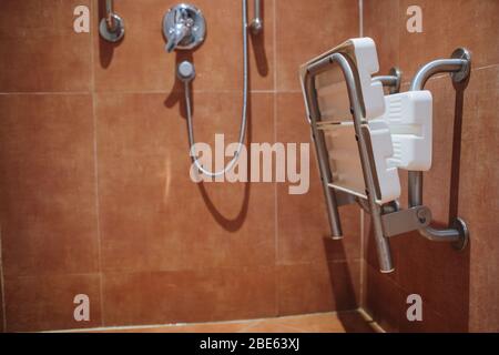 doccia con sedile e maniglioni per disabili e anziani in bagno Foto Stock