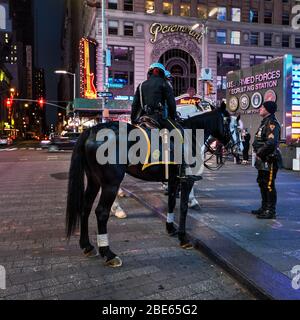 Gli ufficiali della polizia di NY si trovano in una piazza Times quasi vuota durante la chiusura della città per il coronavirus, covid-19, pandemia Foto Stock