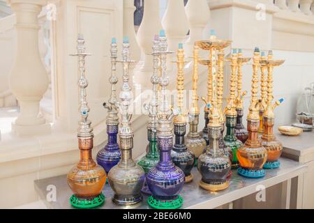 Gruppo di moderni elettrodomestici in ceramica e vetro o Shisha sul bancone del bar in legno bianco, ristorante con vista mare Foto Stock