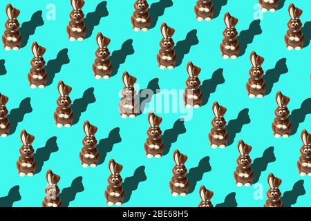 Motivo pasquale alla moda fatto di conigli di cioccolato su sfondo blu in stile minimal. Concetto pasquale in stile minimale. Foto Stock
