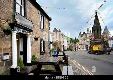 Street scene con lo storico Coventer Hotel e la Fontana Bruce nella piazza principale nel piccolo villaggio di Falkland, Fife, Scozia, Regno Unito, Europa Foto Stock