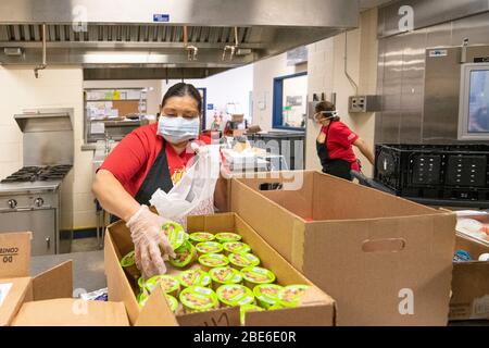 Bambini Nutrition staff pack sacchetti pasto per famiglie che soffrono dal COVID-19, coronavirus pandemico 8 aprile 2020 a San Antonio, Texas. Il servizio USDA Food and Nutrition sta distribuendo pasti per i bambini nelle scuole in tutto il paese. Foto Stock