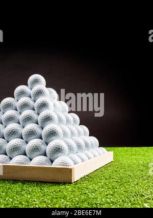 Primo piano della piramide di palle da golf in un campo pratica, vista laterale, immagine verticale Foto Stock