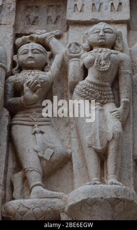 Posa sculture femminili scolpite nelle pareti esterne del tempio di Jagdish ornato di Vishnu, Udaipur, Rajasthan, India, Asia. Foto Stock