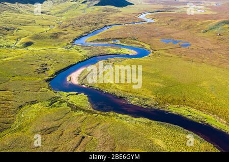 Drone sparare su s curva forma fiume attraverso la valle verde dalla montagna Beinn Spionnaidh in giornata autunnale nel Nord Ovest Highlands della Scozia Foto Stock