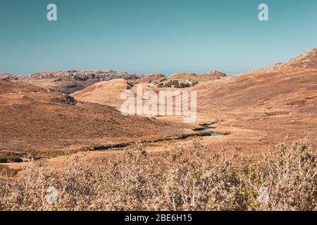 Ruscello tortuoso attraverso la valle panoramica in autunno nelle Highlands del Nord Ovest della Scozia Foto Stock