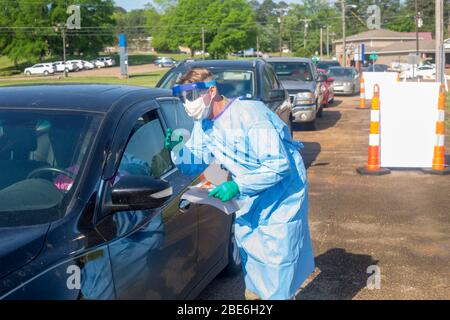 Esercito degli Stati Uniti Sgt. James Todd, spiega la procedura di screening COVID-19 ai pazienti di un centro di test mobile drive up presso il Webster County Human Services Building 9 aprile 2020 a Eupora, Mississippi. Foto Stock