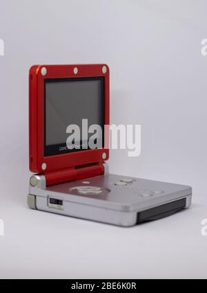 Game boy Advanced SP console portatile da Nintendo da 2003 in rosso argento Super Mario Edition. Aperto, spento con gioco inserito su bianco Foto Stock