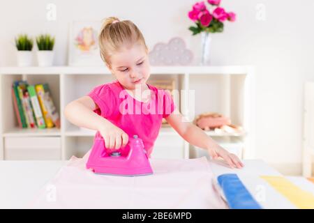 Bambina gioca con il giocattolo di ferro e asse da stiro Foto stock - Alamy
