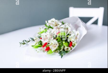 Bouquet di fiori di alstroemeria bianchi in giace su un tavolo bianco rotondo Foto Stock