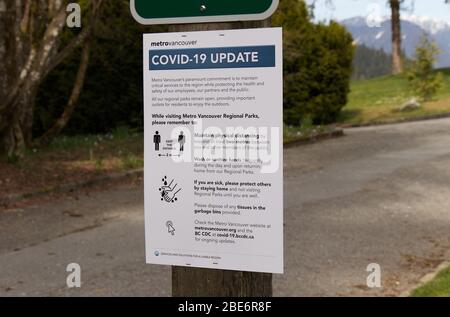 Vancouver, Canada - 8 aprile 2020: Il cartello informativo 'aggiornamento COVID-19' mostra come prevenire la diffusione del virus durante la visita dei parchi regionali Metro Vancouver Foto Stock