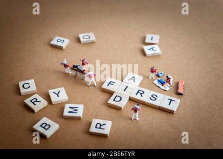 Paramedici in miniatura che forniscono il primo soccorso a pazienti feriti Foto Stock