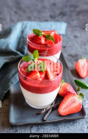 Tradizionale panna cotta con salsa di fragole, servita in un vaso di vetro Foto Stock