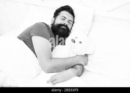 Tanga pigro relax nella camera da letto. Buona notte e dolci sogni. uomo barbuto orsacchiotto a letto. Il giocattolo di peluche concetto. buon compleanno presente. è il momento di andare a dormire. trascorrere il weekend a letto. Confortevole a casa. Foto Stock