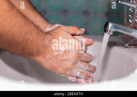 Uomo che lava le mani con sapone per l'igiene del virus Foto Stock