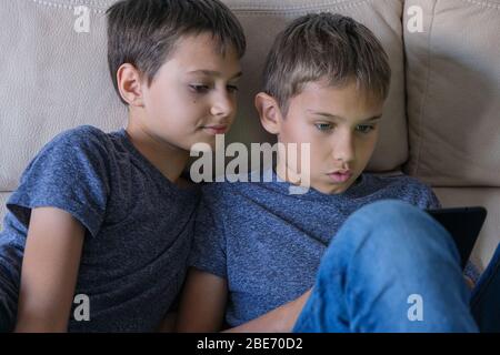 I bambini che utilizzano il computer tablet digitale a casa. Tecnologia, apprendimento online, formazione a distanza, giochi educativi per bambini Foto Stock