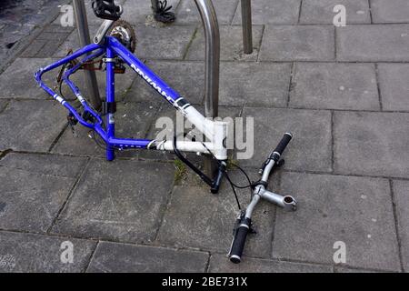 La bicicletta vandalizzata spogliò la maggior parte delle sue parti rimovibili mentre era chiusa in strada pubblica ora abbandonata Foto Stock