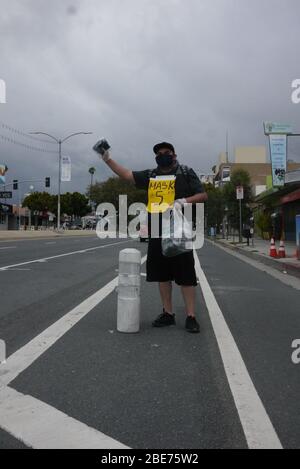 I venditori ambulanti vendono prodotti per la sanificazione delle mani e maschere lungo il lato di Venice Blvd. Foto Stock