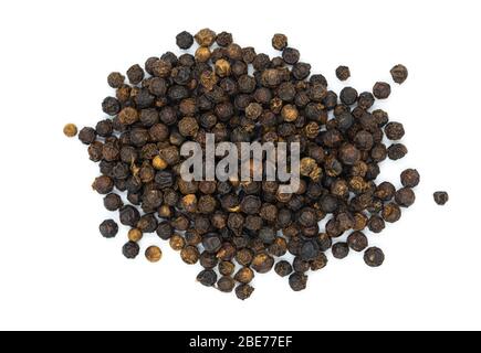 Organico crudo pepe nero mucchio su sfondo bianco in vista macro superiore. Il pepe nero è erbe e spezie per cucinare ingredienti o condimento, aromi Foto Stock