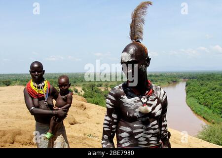 Membri di Karo Tribe vestiti in modo tradizionale e decorati che posano per una foto sulla cima delle rive del fiume Omo Foto Stock