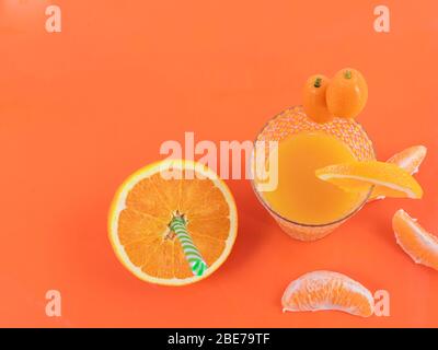Succo d'arancia, arance piccole e arance a fette su fondo arancione - arancia nutriente e gustosa Foto Stock