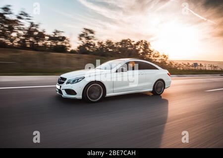 Auto di lusso bianca al tramonto Foto Stock