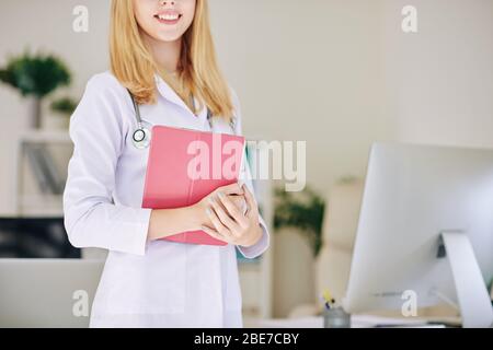 Immagine ritagliata di una donna sorridente medico in un labcoat che tiene tablet digitale Foto Stock