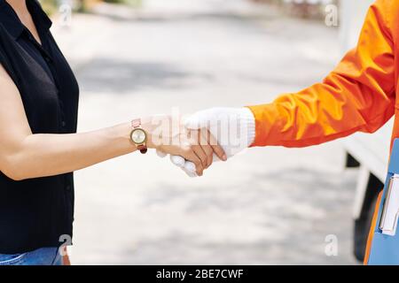 Immagine ravvicinata della donna che scuote la mano del lavoratore in movimento dopo la firma del documento Foto Stock
