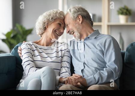 Sorridente coppia matura godendo momento tenero a casa Foto Stock