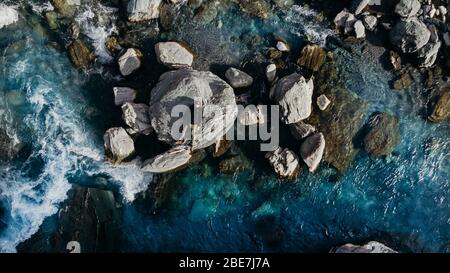 Sparato aereo sopra un uomo adagiò sulla roccia nel fiume blu Nuova Zelanda. Foto Stock