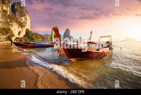 Long Tail barche sulla spiaggia tropicale al bel tramonto in Thailandia Foto Stock