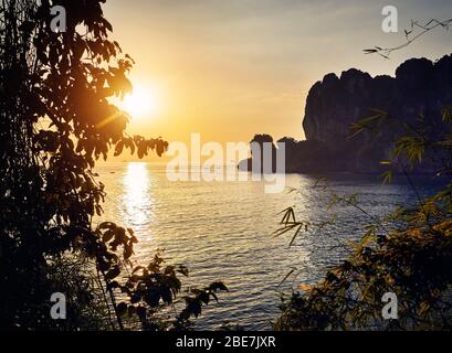 Bella Baia tropicale con spiaggia di sabbia e roccia al tramonto nel Mare delle Andamane, Thailandia Foto Stock